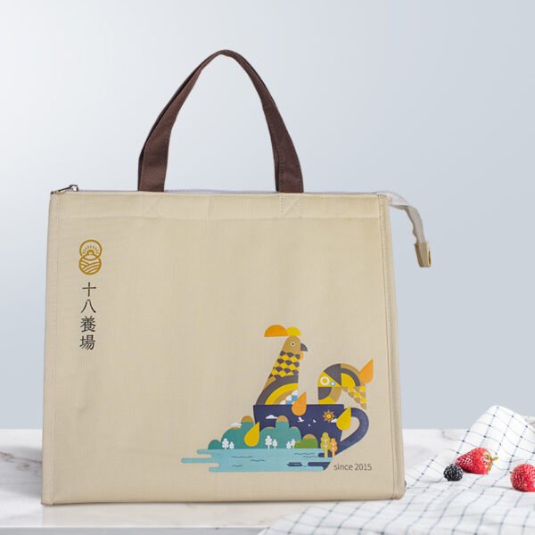 Custom beige cooler bag front view Front view of custom beige insulated cooler bag with brown handles, zipper, and cartoon illustration
