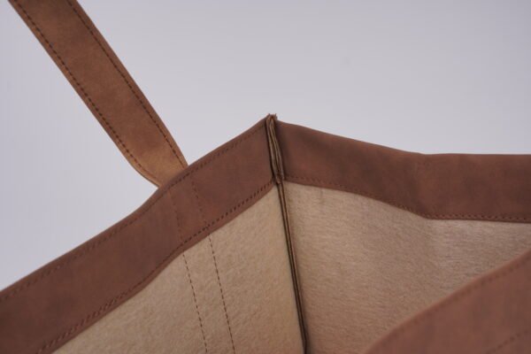 Reinforced edge stitching detail Close-up of the bag opening showing the premium pressed edge stitching and reinforced handle attachment on the suede PU tote bag.