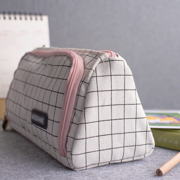 Triangular upright pencil case side view Side view of triangular canvas pencil case demonstrating its sturdy upright standing structure with black label detail