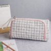 Black grid pencil case with pink zipper Custom black grid cotton canvas pencil case with pink zipper and round metal pull on a desk