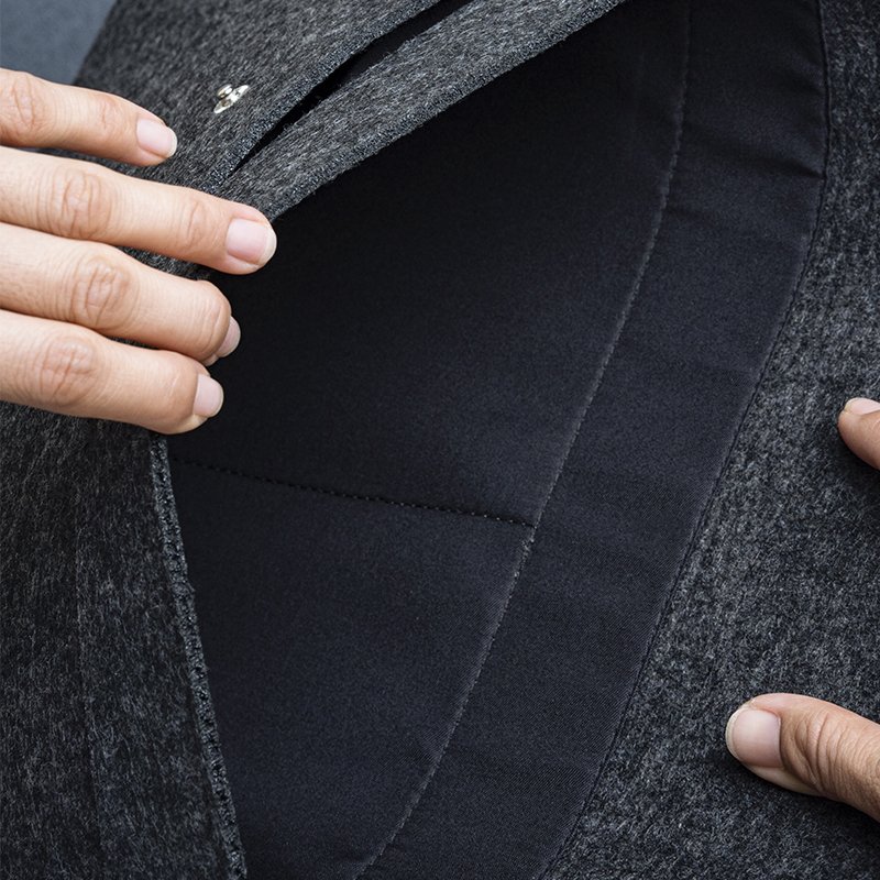 Close-up of opened felt laptop sleeve revealing soft inner lining and neat, flat stitching