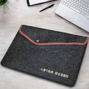 Felt laptop sleeve front view Front view of custom deep grey felt laptop sleeve with leather trim and gold logo
