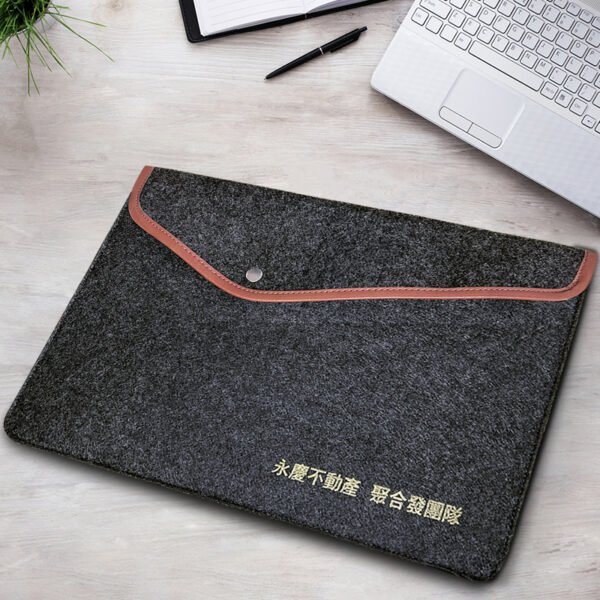 Front view of custom deep grey felt laptop sleeve with leather trim and gold logo
