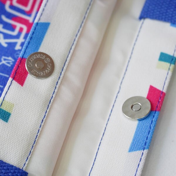 Flat-lay view of the bag opening showing metal magnetic snap closure and reinforced stitching on the bag mouth.