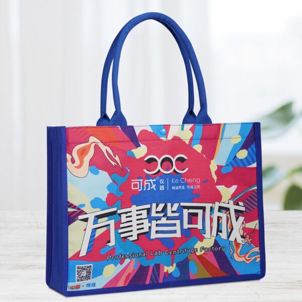 Alt Text: Custom digital printed canvas tote bag with blue handles and magnetic snap