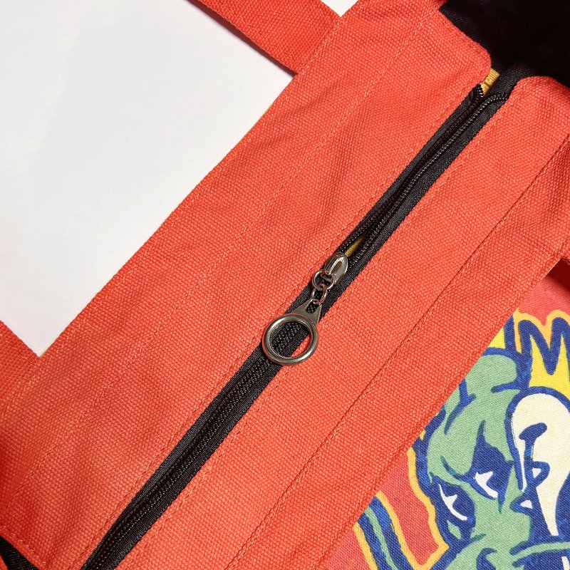 Close-up of the closed zipper and stylish customized zipper pull on the 16oz canvas tote bag