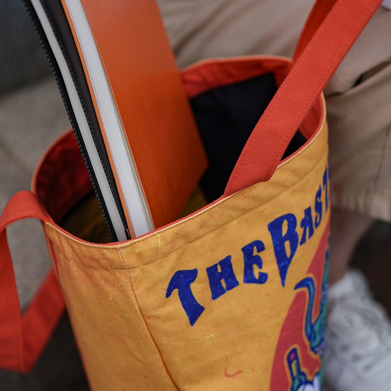 Open custom canvas tote bag with a notebook inside, showing the peach skin lining and inner pocket