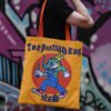 Yellow 16oz cotton canvas tote bag with double-sided graphic print worn on shoulder