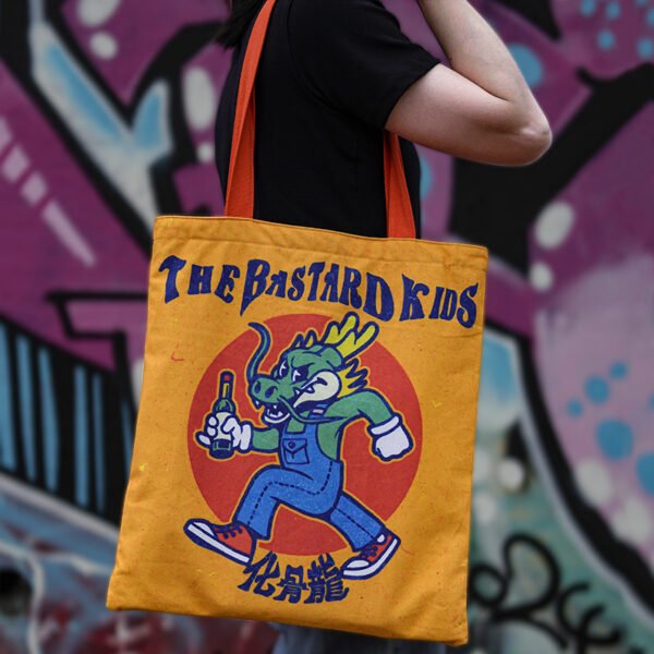 Yellow 16oz cotton canvas tote bag with double-sided graphic print worn on shoulder