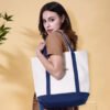 Woman carrying a large custom two-tone canvas tote bag for travel and hotel use
