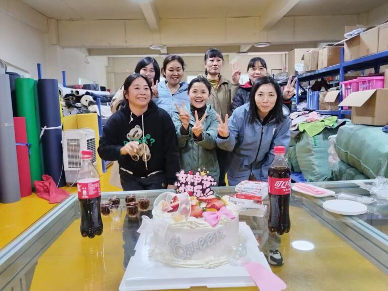 Gongfu Pinke female factory workers celebrating Women's Day with a cake and smiles in the workshop.