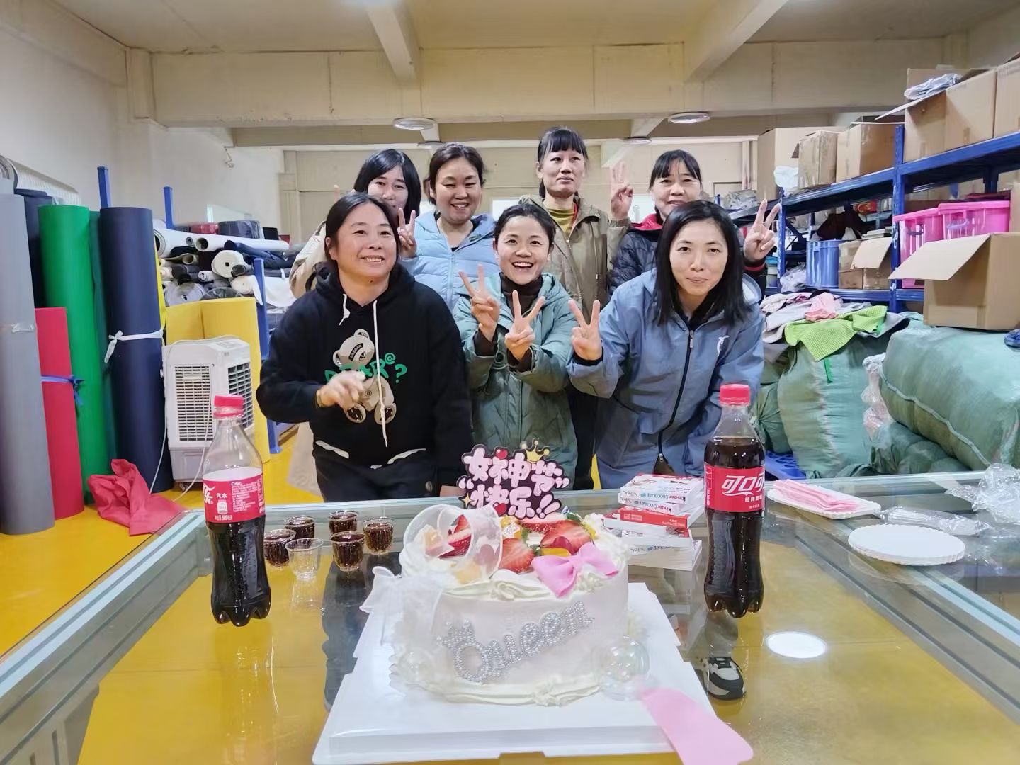 Gongfu Pinke female factory workers celebrating Women's Day with a cake and smiles in the workshop.