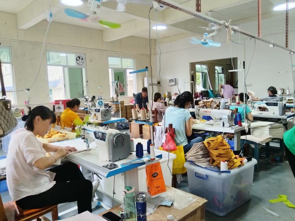 Skilled workers operating sewing machines in a custom bag manufacturing factory in Guangzhou, China.