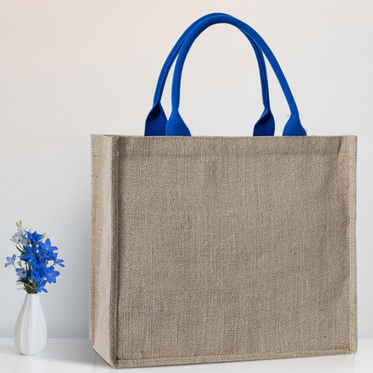 Custom natural jute tote bag with blue woven handles displayed in a minimalist setting.