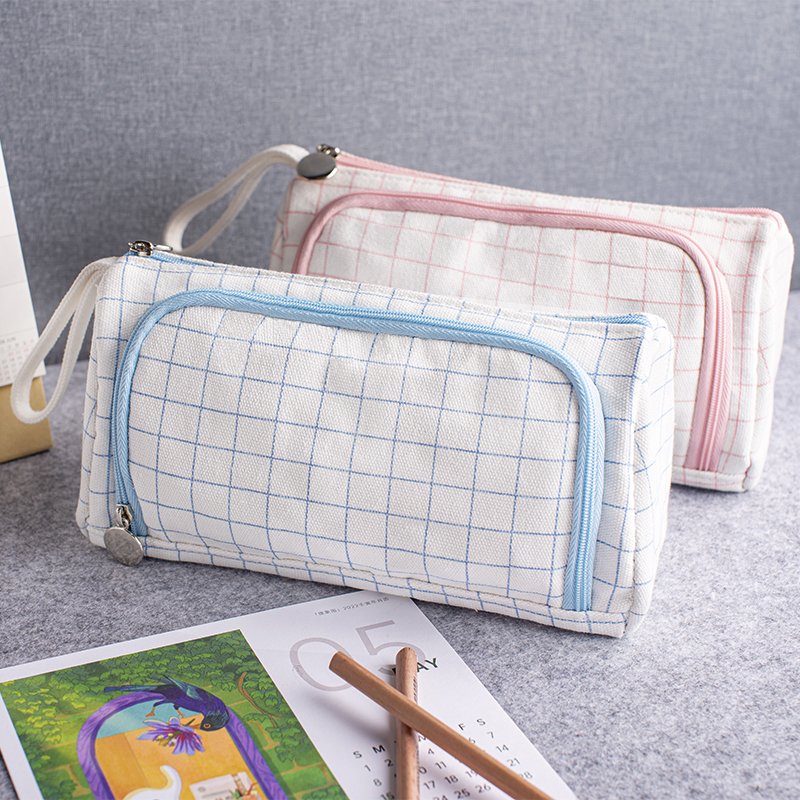 Two custom cotton canvas grid pencil cases in blue and pink with wrist straps and zippers
