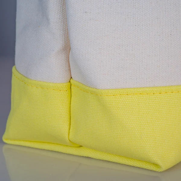 Reinforced bottom stitching detail Close-up detail of the 12cm sturdy bottom and reinforced stitching on a two-tone canvas tote bag