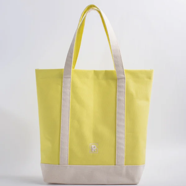 Yellow canvas tote bag front view ellow and natural two-tone canvas tote bag with extended handles and embroidered logo